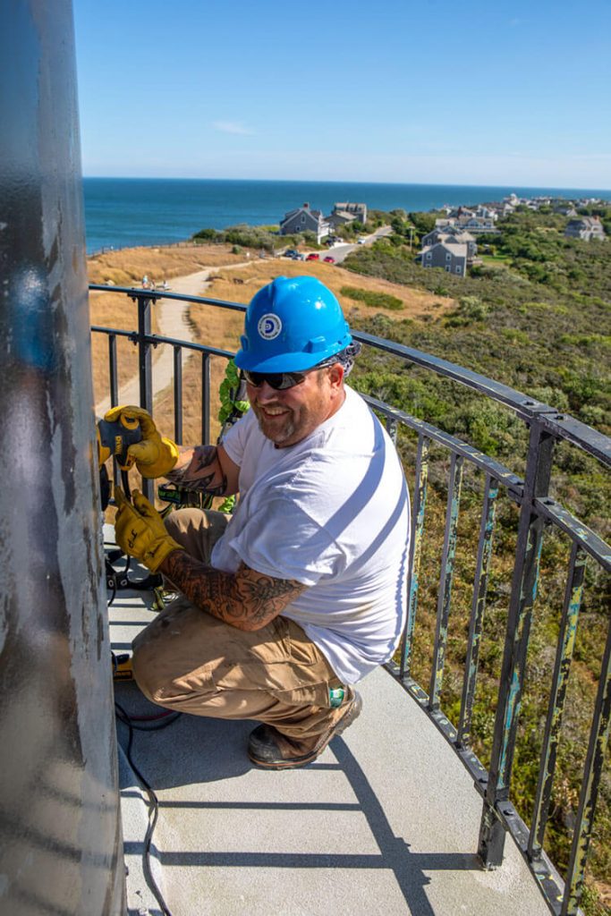 worker cleaning the light house from the deck.
