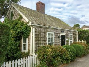 Small shingled cottage with large bushes